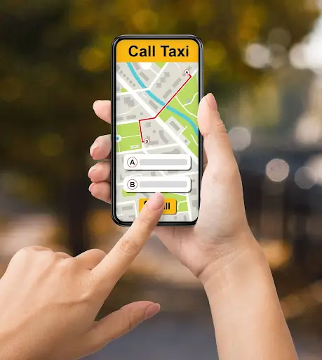 A person holding a smartphone with the PerGo transportation dispatch software app open, showing a map, route, and pickup and drop-off locations, while tapping the call button.